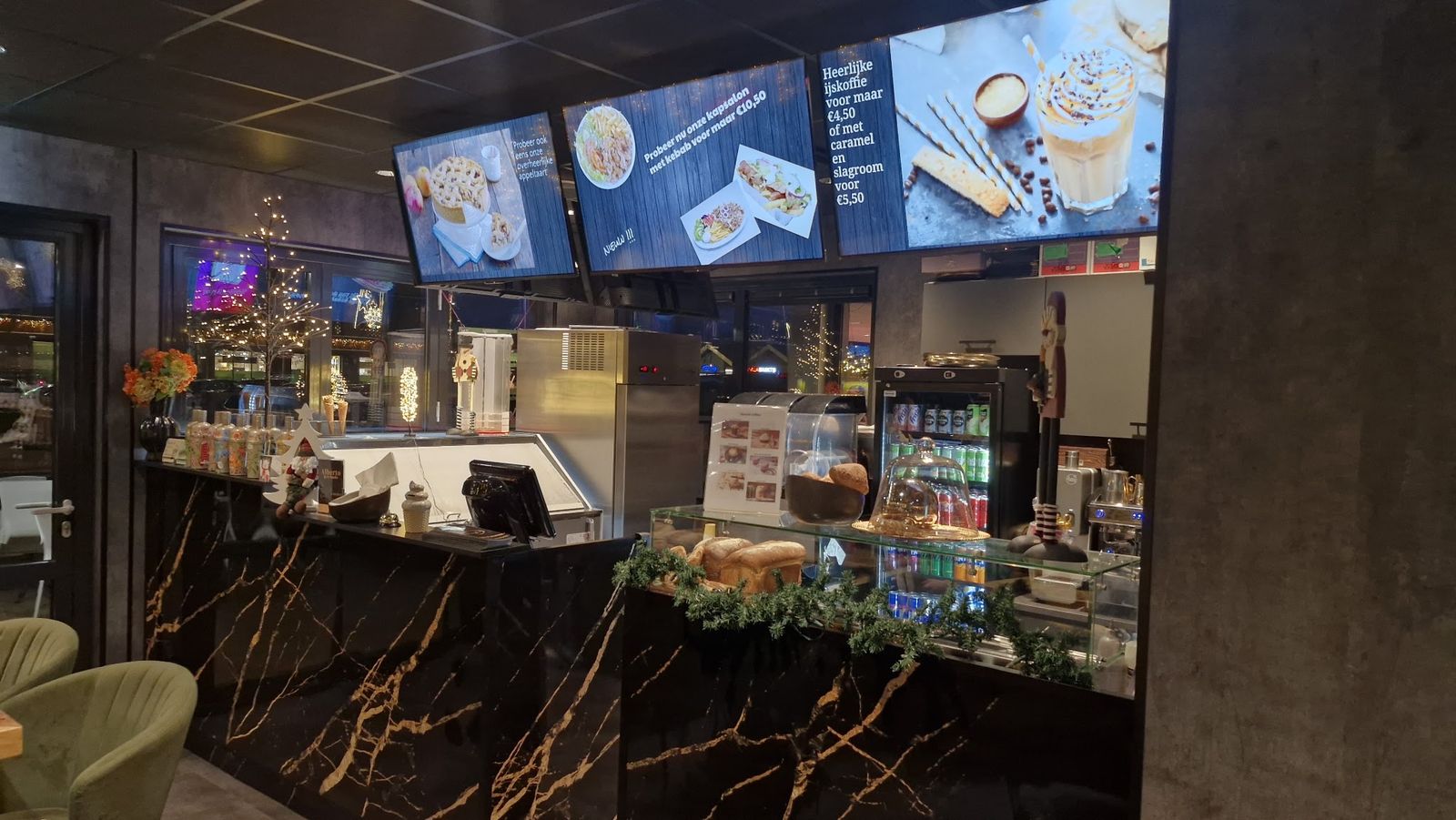 De toonbank met zwart marmer, menuschermen en de ijsvitrine